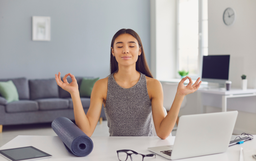  Woman meditating in a home office, embodying work-life balance facilitated by automated marketing solutions.